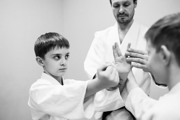 Zdjęcie dzieci w kimonie rozpoczynają trening na aikido.