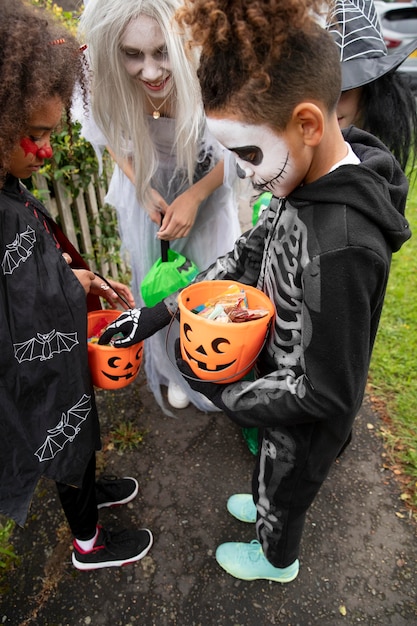 Zdjęcie dzieci w kostiumach patrzące na swoje cukierki na halloween