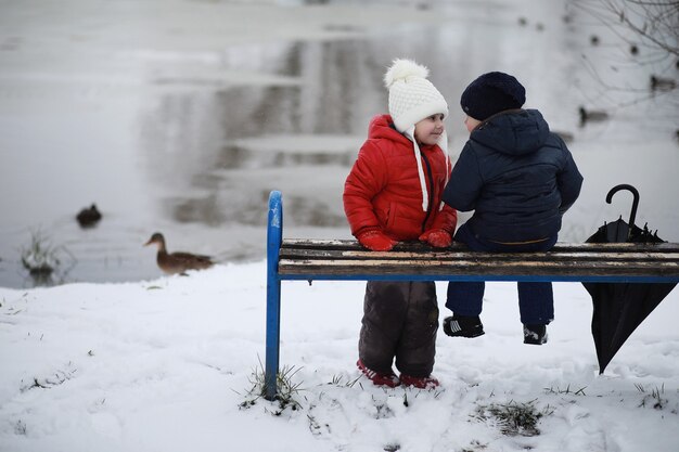 Dzieci w parku zimowym bawią się śniegiem