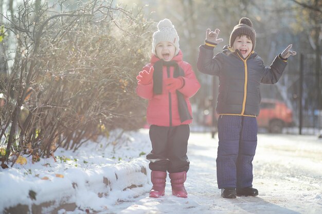 Dzieci w parku zimowym bawią się śniegiem