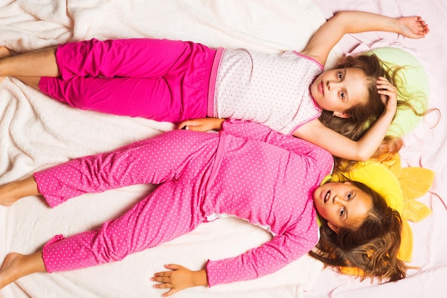 Dzieci w różowej piżamie bawią się Dzieci ze zmęczonymi twarzami