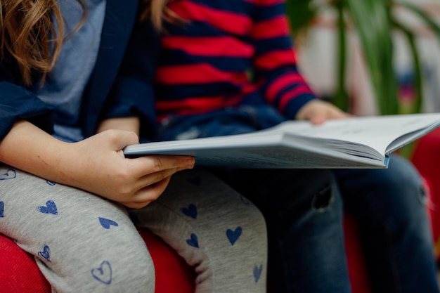 Dzieci w wieku szkolnym w bibliotece czytają książki, odrabiają lekcje, przygotowują szkolny projekt na lekcje