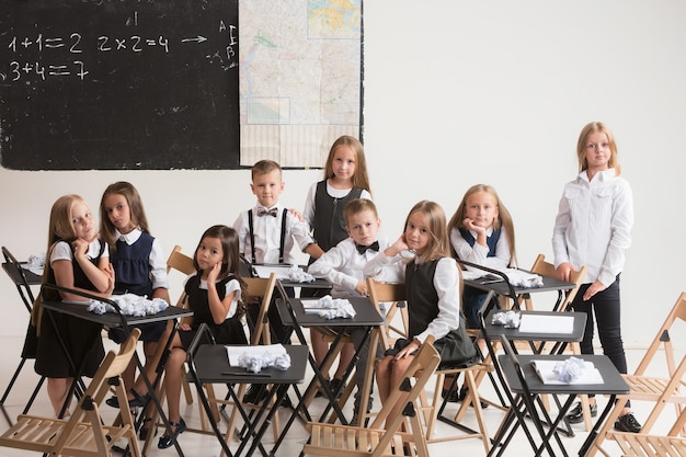 Zdjęcie dzieci w wieku szkolnym w klasie na lekcji. mali chłopcy i dziewczynki siedzą przy biurkach. powrót do szkoły, edukacji, klasy, lekcji, nauki, stylu życia, koncepcji dzieciństwa