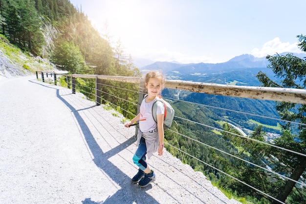 Dzieci Wędrują W Letnie Dni W Alpach Austrii, Odpoczywając Na Skale I Podziwiając Niesamowity Widok Na Szczyty Górskie. Aktywne Rodzinne Wakacje Z Dziećmi.