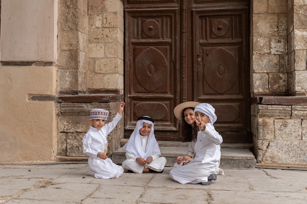 Dzieci z Arabii Saudyjskiej bawiące się przed domem na starym mieście w Dżuddzie, w Arabii Saudyjskiej