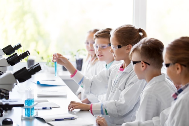 Dzieci z probówkami uczące się chemii w szkole.