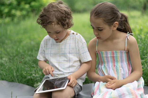 Dzieci Z Tabletem Na Zewnątrz Dzieci Grają W Gry Na Tablecie