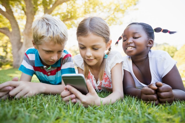 Dzieci za pomocą smartfona w słoneczny dzień