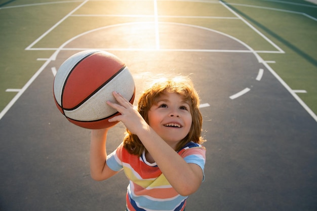Dzieciak grający w koszykówkę z koszykówką, śmiejący się i bawiący się Widok z góry