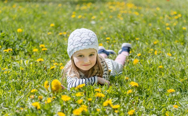 Dzieciak odpoczywa na trawie, otoczony żółtymi kwiatami