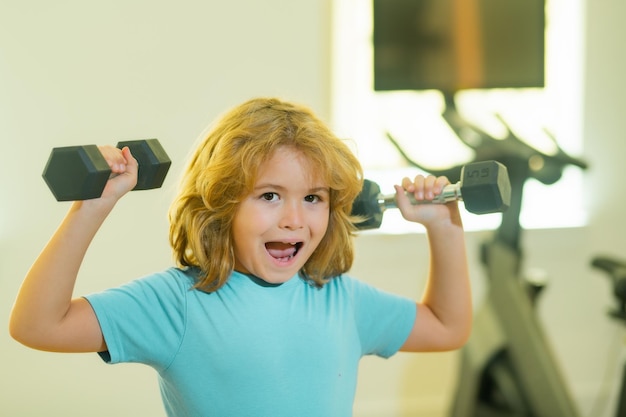 Dzieciak treningu dziecka w siłowni Chłopiec Cute dziecko pompowanie mięśni ramion z hantle Fitness kids with dumbbells