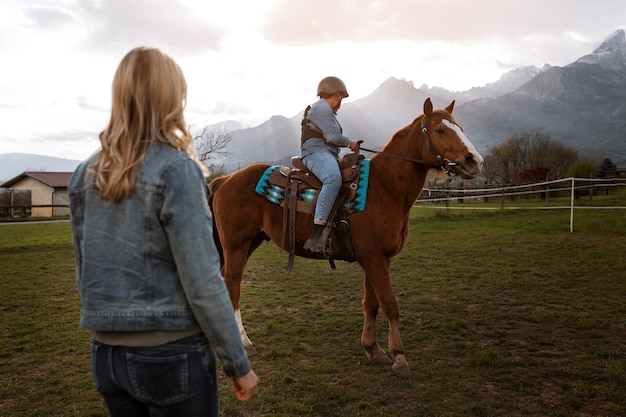 Zdjęcie dzieciak uczy się jeździć konno