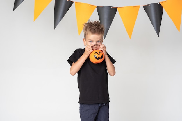 Dzieciaki Halloween Piękny emocjonalny chłopiec w czarnej koszulce trzyma latarnie Jacka na białym studyjnym tle