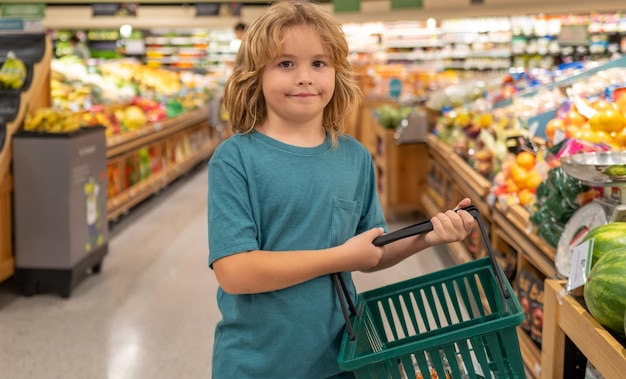 Dzieciaki z koszykiem zakupy z dzieciakami dzieciak kupuje owoc w supermarkecie chłopiec kupuje świeżego ve