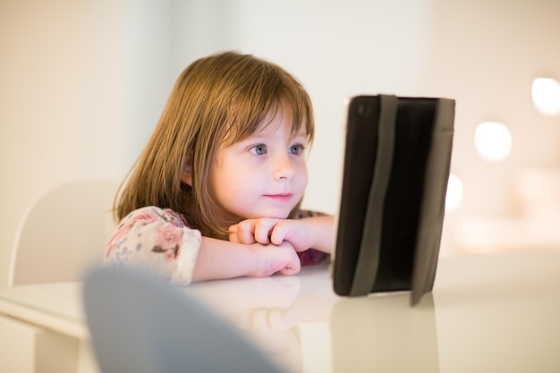 dziecko bawiące się cyfrowym tabletem w domu