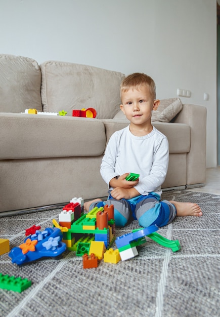 Dziecko bawiące się klockami zabawki, siedząc na podłodze