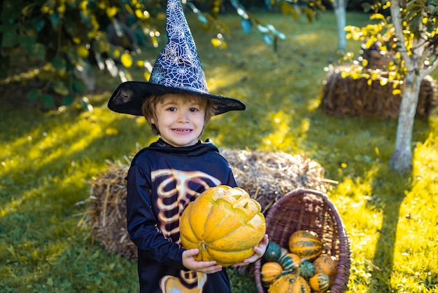 Dziecko bawiące się na Halloween Cukierek albo psikus śmieszne dzieciak w karnawałowych strojach na zewnątrz wesołe dziecko ...