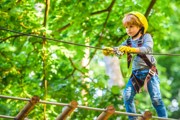 Dziecko Bawiące Się Na Placu Zabaw Park Linowy Aktywne Dzieci Bezpieczne Wspinaczka Sport Ekstremalny Z Kaskiem Szczęśliwe Małe Dziecko Wspinające Się Na Drzewo