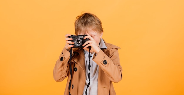 Dziecko chłopiec czerwona głowa fotograf z retro photocamera w studio