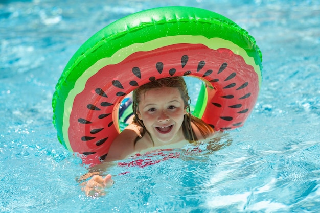 Dziecko chłopiec pływa z pierścieniem pływającym w basenie dzieci letnie wakacje i koncepcja wakacji happy litt