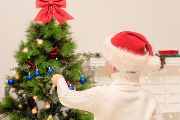 Dziecko Chłopiec W Czerwonym Santa Hat Dekoruje Choinkę Z Bliska Boże Narodzenie Lub Nowy Rok Przytulna Koncepcja Wakacji