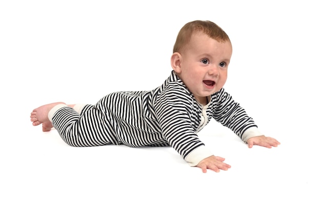 Dziecko czołgające się po podłodze odwracające wzrok i uśmiechające się na białym tle