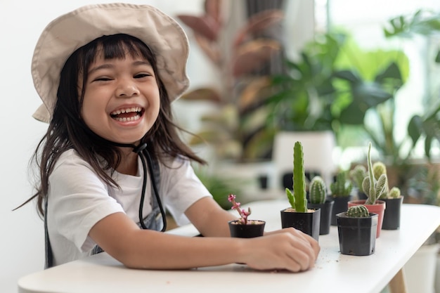 Dziecko Delikatnie Dotyka Nowej łodygi Kaktusa, Który Rośnie Ostrożnie, Jedną Ręką Trzyma Szkło Powiększające Edukacja Przyrodnicza Montessori I Koncepcja Umiejętności Obserwacji