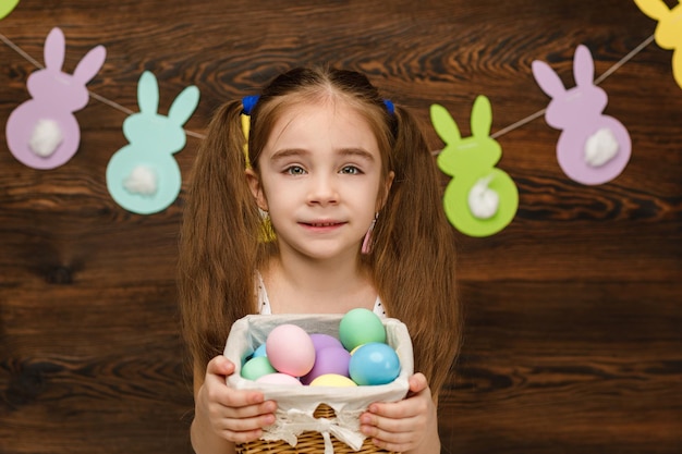 Dziecko dziewczyna trzyma kosz z Wielkanocą