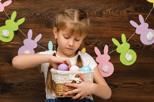 Dziecko dziewczyna trzyma kosz z Wielkanocą