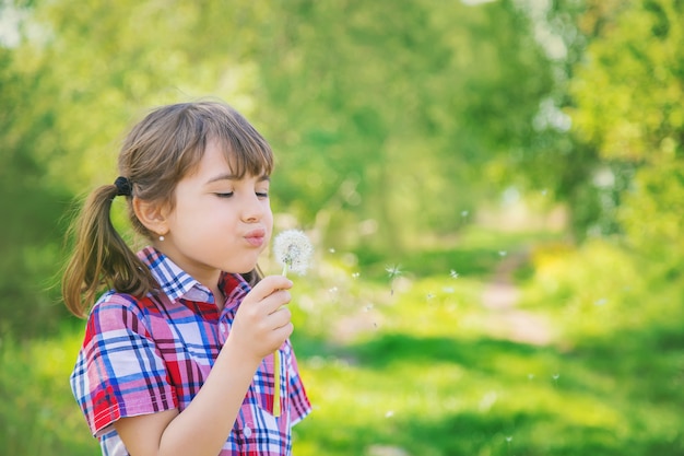 Dziecko dziewczyna z dandelions w parku. Selektywne ustawianie ostrości.