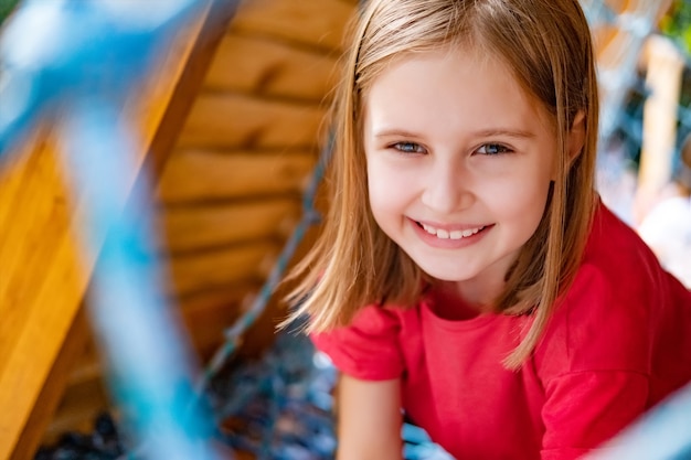 Dziecko dziewczynka bawi się na placu zabaw z siatką w parku