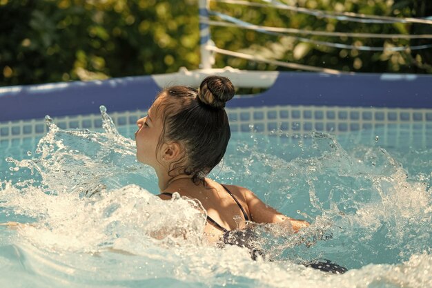 Dziecko dziewczynka lubi pływać w basenie rekreacyjnym na letnie wakacje pływać