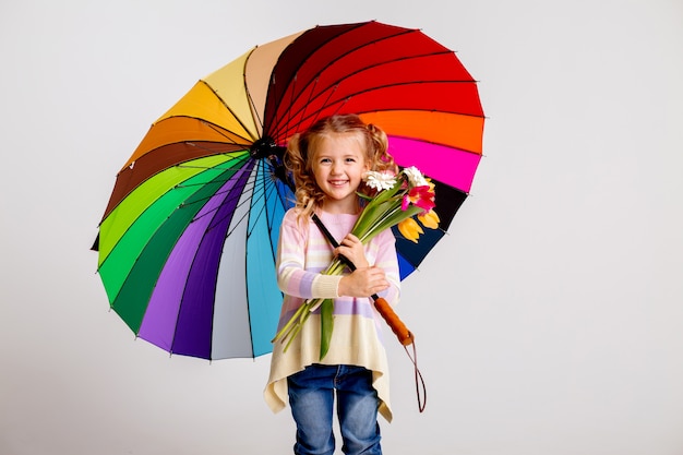 Dziecko dziewczynka w gumowe buty gospodarstwa wielobarwny parasol