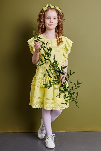 Zdjęcie dziecko dziewczynka w jasne wiosenne ubrania. romantyczny wygląd i uśmiech na twarzy