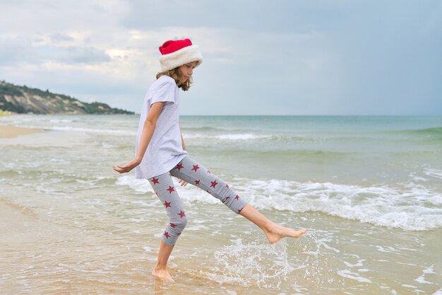 dziecko dziewczynka w kapeluszu Santa zabawy na plaży oceanu