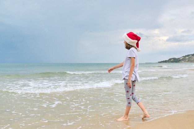 dziecko dziewczynka w kapeluszu Santa zabawy na plaży oceanu