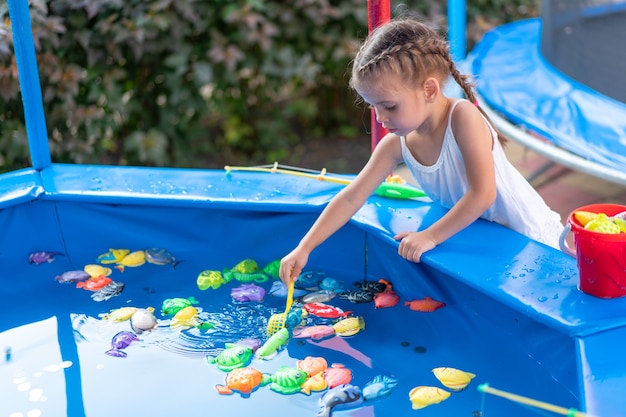 Dziecko Fisher łapanie Plastikowej Zabawki Ryby Na Basenie Park Rozrywki Letni Dzień Mała Dziewczynka Baw Się Dobrze Na Wędkowaniu Karnawał Festiwal Rozrywka Dla Dzieci