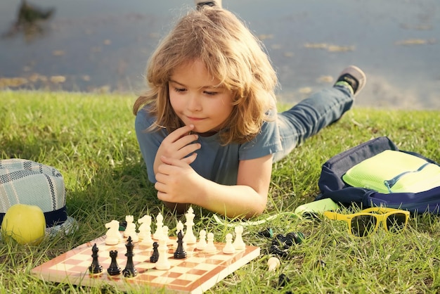 Dziecko gra w szachy wiosną podwórku r. na trawie skoncentrowany grać w szachy dziecko gra