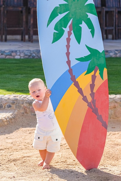 Dziecko idące po plaży z wyciągniętymi ramionami