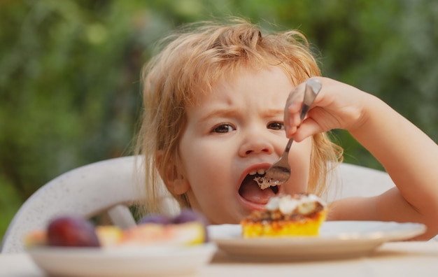 Zdjęcie dziecko je ciasto dziecko je babeczkę na zewnątrz