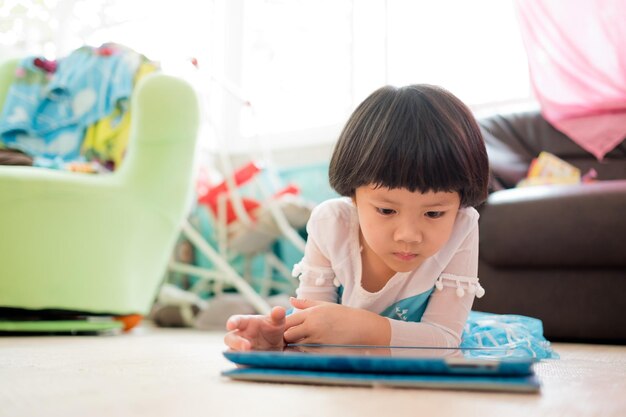 Dziecko jest uzależnione od tabletu mała dziewczynka gra na smartfonie dziecko korzysta z telefonu oglądając kreskówki
