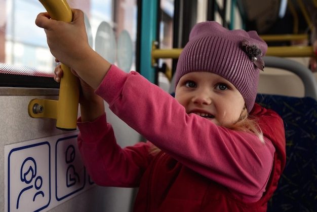 Dziecko jeździ autobusem publicznego nowoczesnego transportu wygląda przez okno Mała dziewczynka w transporcie miejskim