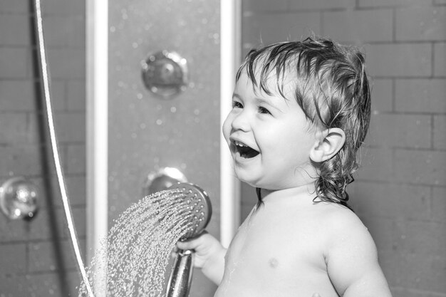 Dziecko kąpi się pod prysznicem Małe dziecko myje włosy w kąpieli