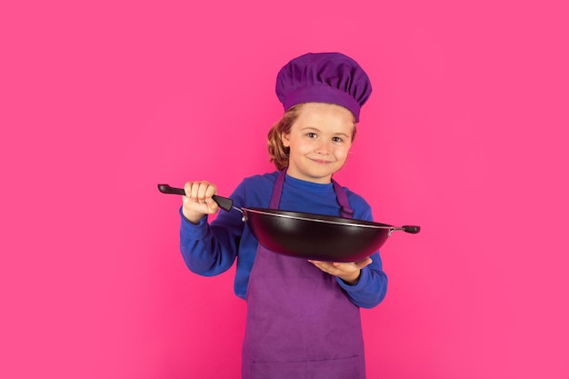 Dziecko kucharz z patelnią Gotowanie dzieci Szef kuchni chłopiec robi zdrowej żywności Portret małego dziecka w kapeluszu szefa kuchni na białym tle na tle studia Dziecko kucharz Proces gotowania