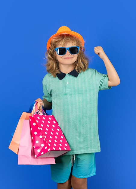 Dziecko kupujące dziecko w modnych ubraniach na zakupach Dziecko kupujące z torbą na zakupy pozuje torby na zakupy na tle studia