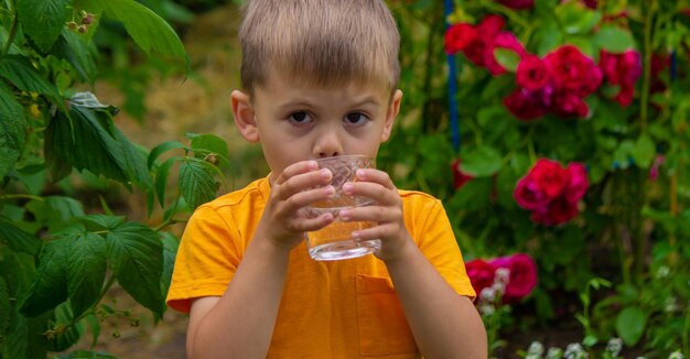 Dziecko latem pije czystą wodę