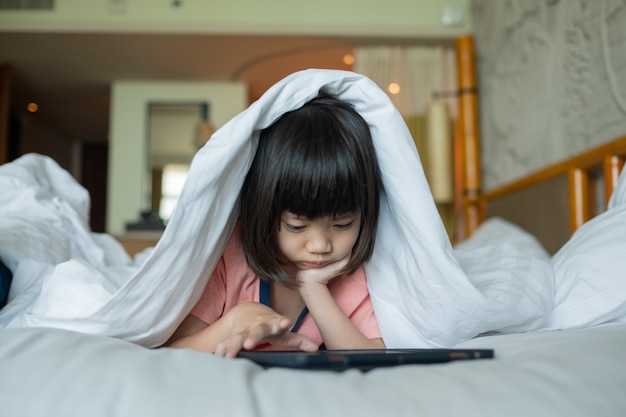 Dziecko oglądając tablet na łóżku, kreskówka uzależniony od dziecka