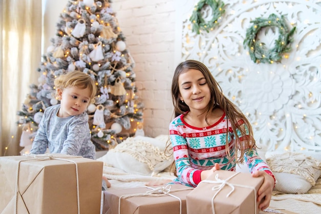 Dziecko otwarte prezenty świąteczne pod drzewem Selektywne fokus
