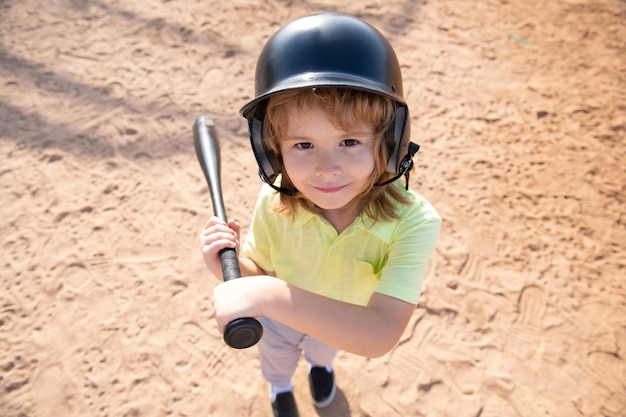 Dziecko pałkarz ma zamiar uderzyć w boisko podczas meczu baseballowego dzieciak gotowy do uderzenia