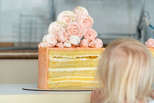 Dziecko patrzy na duży piękny tort Ciasto na przyjęcie dla dzieci